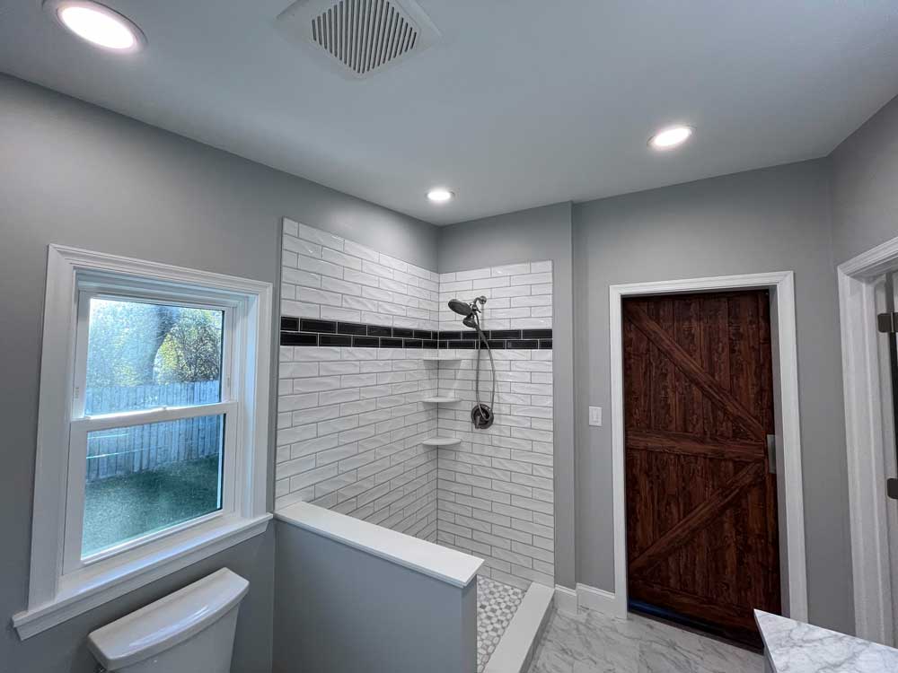 Bathroom barn door and a tiled shower.