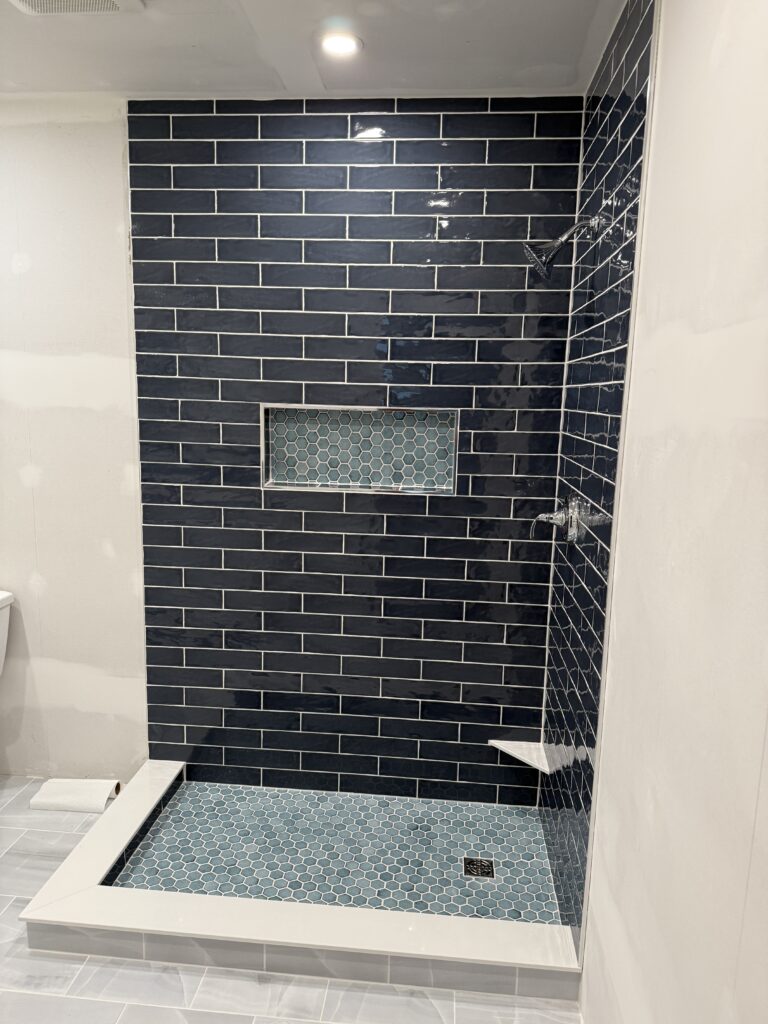 Bathroom shower tiled with 28 inch niche and chrome fixtures